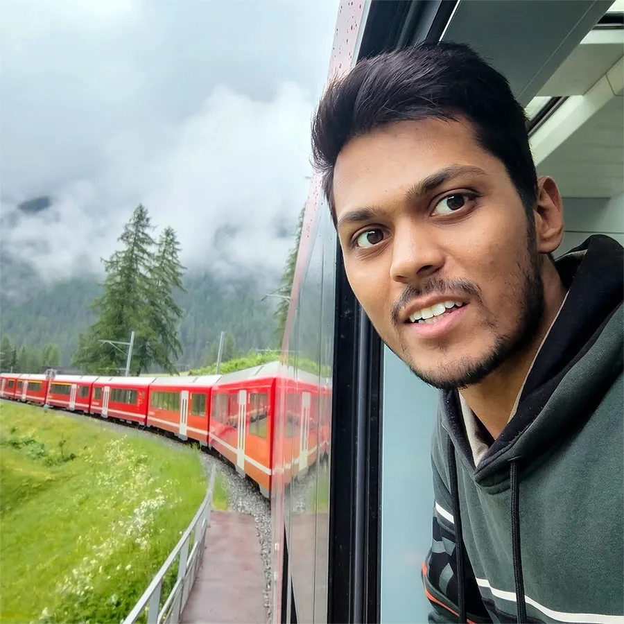 Harsh P leaning out of a train window in the Swiss Alps